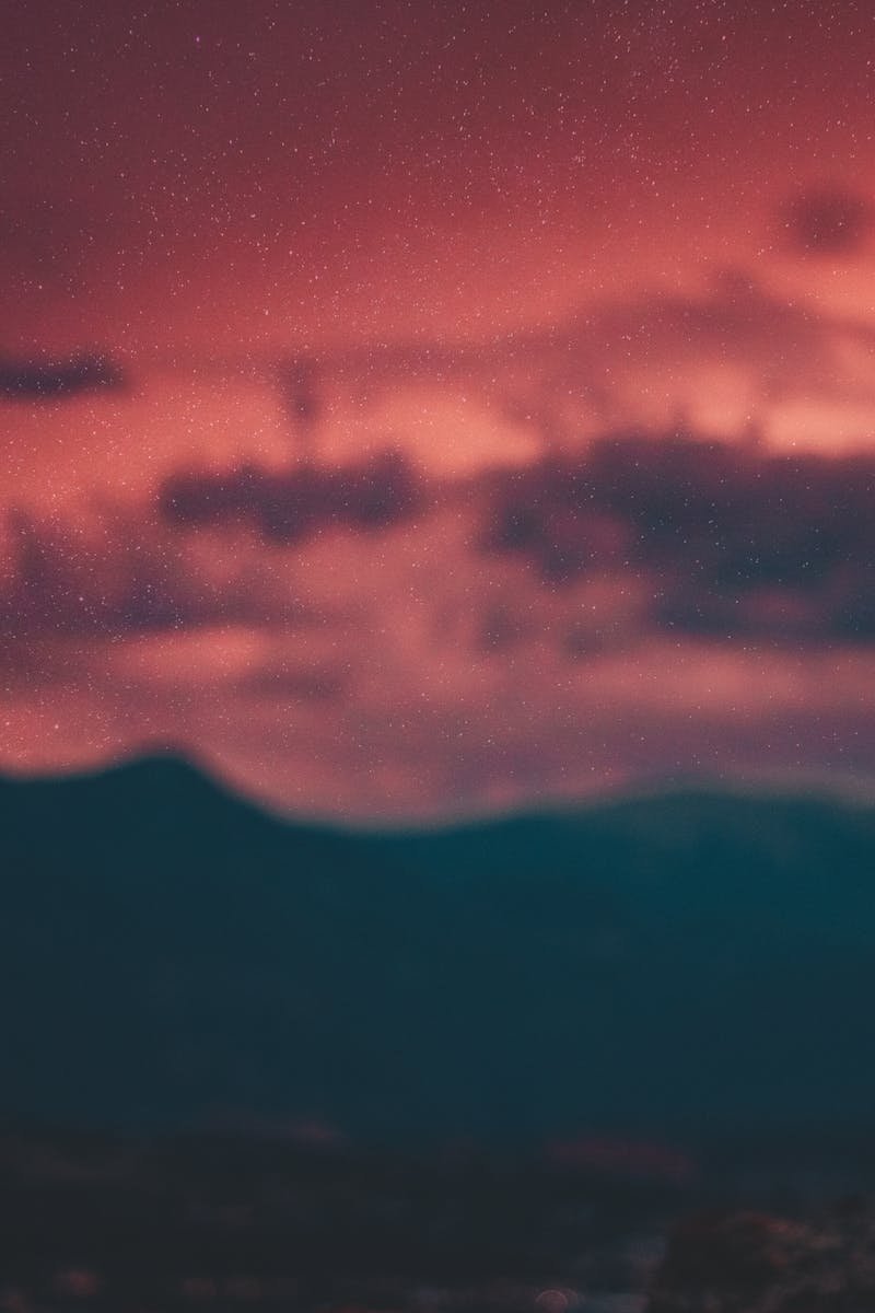 A lone silhouette against a vibrant red twilight sky in Colorado Springs.